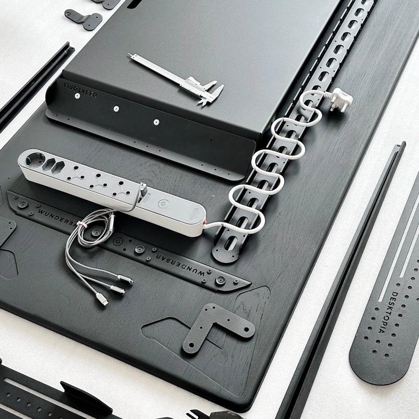 Collection of engineer desk tools and equipment on a black surface with a white background